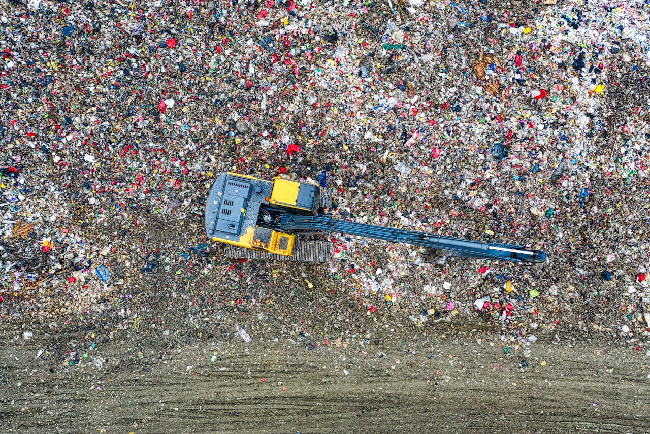 hero-img-01 Aerial shot of an excavator working at a large waste disposal site in Banten, Indonesia.
